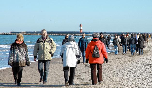 Gut besucht: Zahlreiche Besucher spazieren den Strand im Ostseebad entlang.