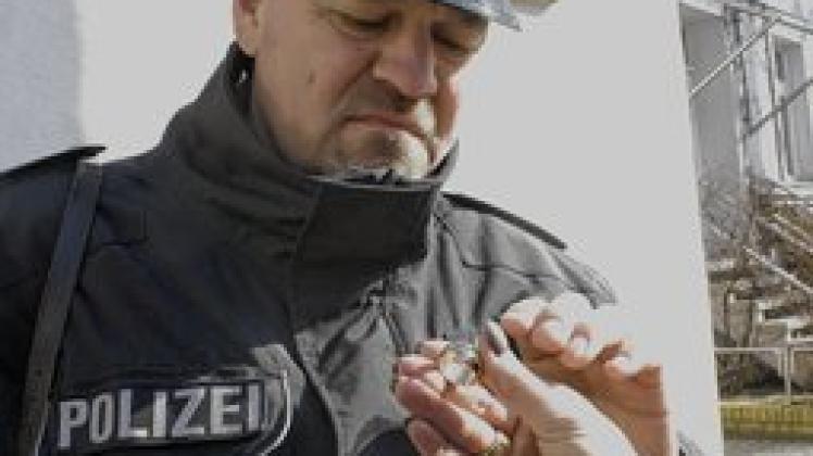 Polizeioberkommissar Matthias Bartsch begutachtet den Ring aus Blech und den Tatort. Fotos: mapp