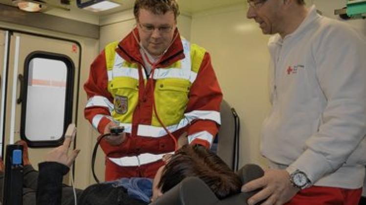 Blutdruckmessen: Rene Grove (l.) und Rettungsassistent Michael Splittgerber helfen einer Patientin mit Kreislaufproblemen. Foto: Hoffmann