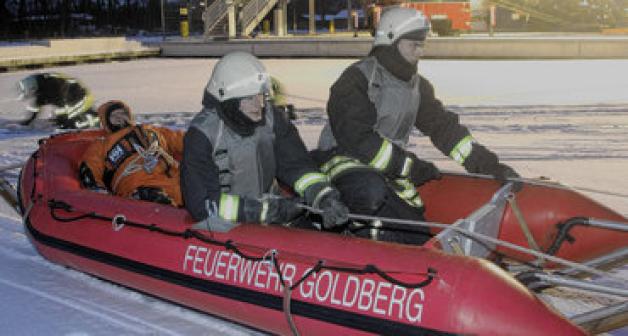 Florian Kauke (l.) und Andreas Melzer bringen den "Geretteten" mit dem Schlauchboot auf einem Eisschlitten ans Ufer.