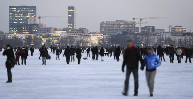 Tausende Menschen sind am Freitag bei einbrechender Dunkelheit noch auf der zugefrorenen Außenalster in Hamburg unterwegs. Foto: Marcus Brandt dpa