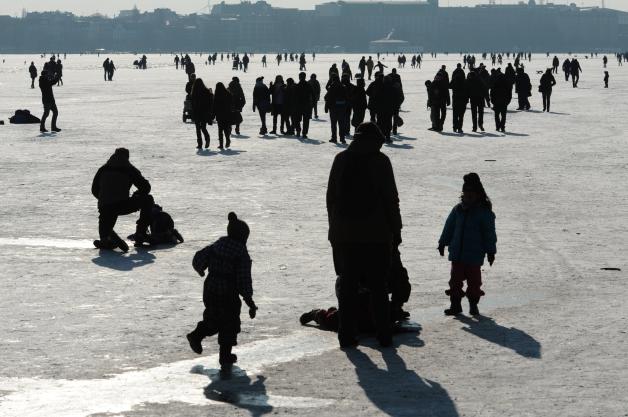 Spaziergänger gehen am Freitag über die zugefrorene Hamburger Außenalster. Deutschlands größte Winterparty ist gestartet. Foto: Christian Charisius dpa