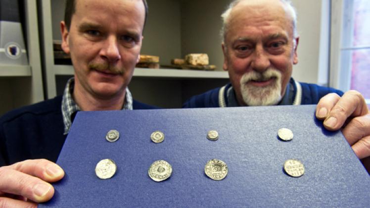 Die Bodendenkmalpfleger Steffen Berndt  (rechts)und Gerd Sobietzky mit Münzen, die in der Lüdershagener Kirche  gefunden wurden.  stefan Sauer/zb
