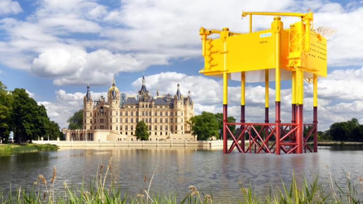 Soll die Größenverhältnisse etwas verdeutlichen:  Eine Collage, die Plattform und Schweriner Schloss zeigt Nordic Yards\|Offshore-Plattform