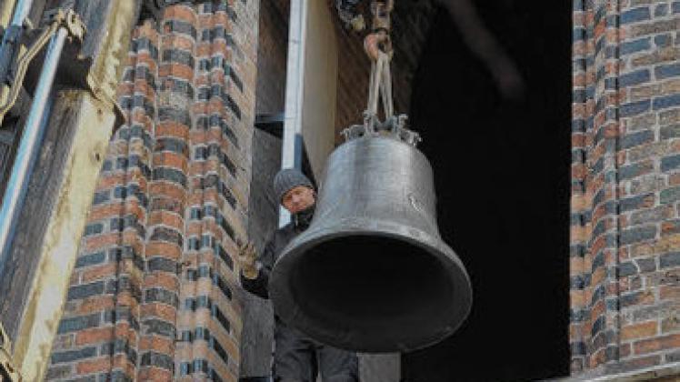 Klangvolles Schmuckstück: Die neue Glocke wird in den Marien-Turm gehoben. Monteur Mathias Heitmann gibt dem Kranführer  Zeichen für das richtige Positionieren.Georg Scharnweber