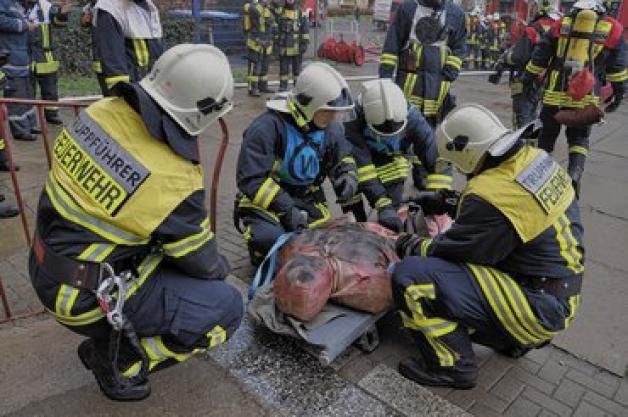 Truppführer der Feuerwehr sichern das Opfer, eine Puppe,  auf einer Trage.Nicole Pätzold