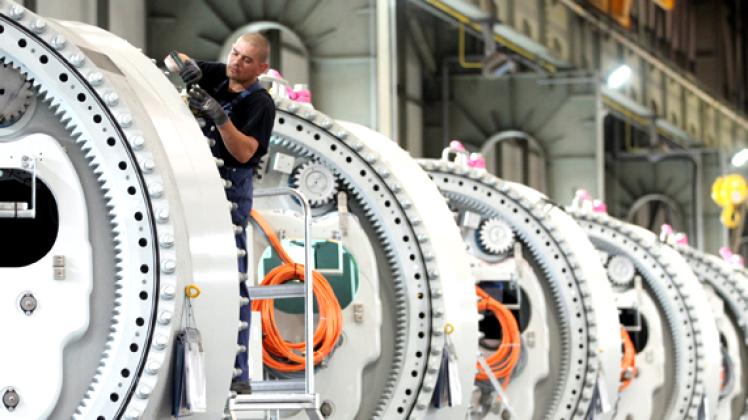 Ein Mitarbeiter der Nordex AG arbeitet in einer Produktionshalle in Rostock an einem sogenannten PVE, dem Verbindungselement fuer die Nabe einer Windkraftanlage. Foto: dapd