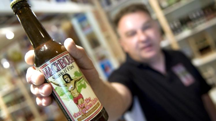 Getränkehändler Günter Eckert zeigt  in seinem Geschäft in Cottbus eine Flasche der Marke "Machbuba Sklavin und Fürst", auf deren Etikett eine barbusige Frau zu sehen ist. dapd