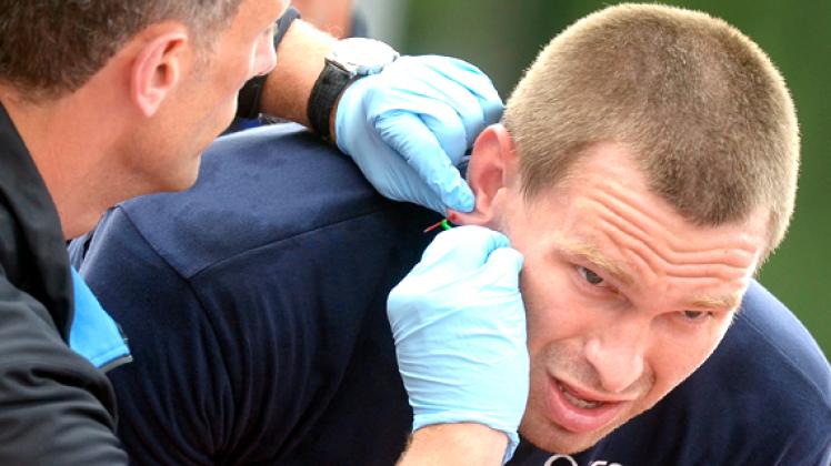 Dr. Tilo Sasse zapft Keeper Jörg Hahnel, der   mit frischer Kurzhaarfrisur erschien, Blut aus dem Ohr ab.