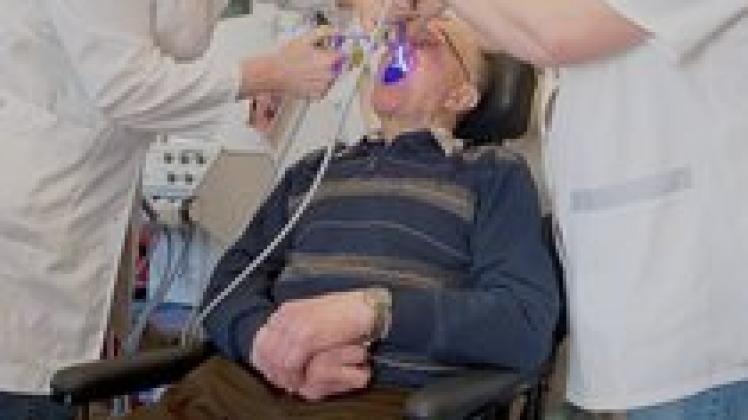  Dr. Kerstin Finger behandelt gemeinsam mit Zahnarzthelferin Christine  Zessel einen Rentner im Seniorenheim von Milmersdorf. Dank ihrer mobilen Technik sind die Therapien vor Ort möglich.dpa