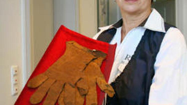 Norma Schmitz zeigt Handschuhe aus Muschelseide, die  Besucher in der Zoologischen Sammlung   der Uni Rostock bewundern können. 
