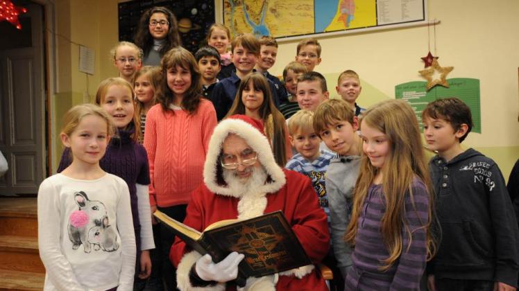Bei seinem Besuch in der Fritz-Reuter-Schule las der Weihnachtsmann den Kindern aus der dritten Klasse auch eine Geschichte vor.  
