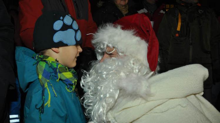 Malte Bauer (7) sagte dem Weihnachtsmann was ins Ohr und erhielt etwas aus dem Süßigkeitensack. Fotos: hans-jürgen kowalzik (4) 