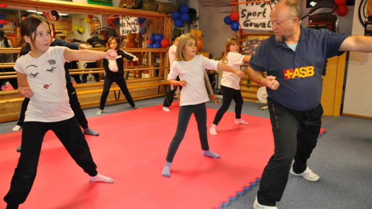 Zusammen zeigen die Kinder mit ihrem  Trainer und Projektleiter Harry Tarassow „Action-Übungen“, die sich   an der japanischen Kampfkunst Karate orientieren. Spielerisch soll den Dritt-bis Sechstklässlern ein ernstes Thema nahegebracht werden. Fotos: Thomas Stengel 