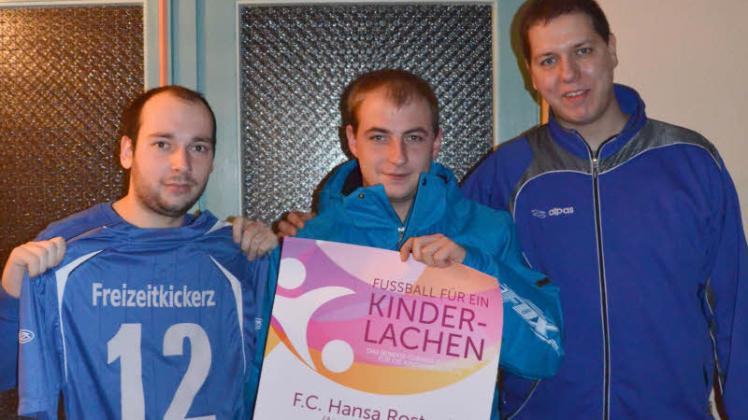Matthias Retzlaff, Christoph Sander und Sascha Träger  zeigen ihr Vereinstrikot und das Plakat für das Benefizturnier der Freizeitkickerz  