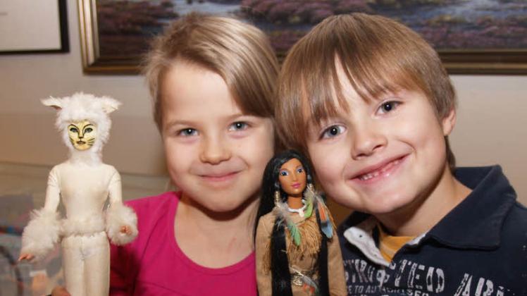 „Cats“-Puppe und Pocahontas: Alina Leisering und Christopher Phillip Bach mit zwei von Birgit Bach gestalteten Barbies. 