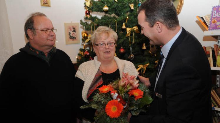 Mit einem Weihnachtsstrauß dankt am Heiligabend  Torsten Uhe (r.), erster Beigeordneter des Landrates, Marlies Müller und Günter Kolip für ihren ehrenamtlichen Einsatz für die Prignitzer Tafeln. 