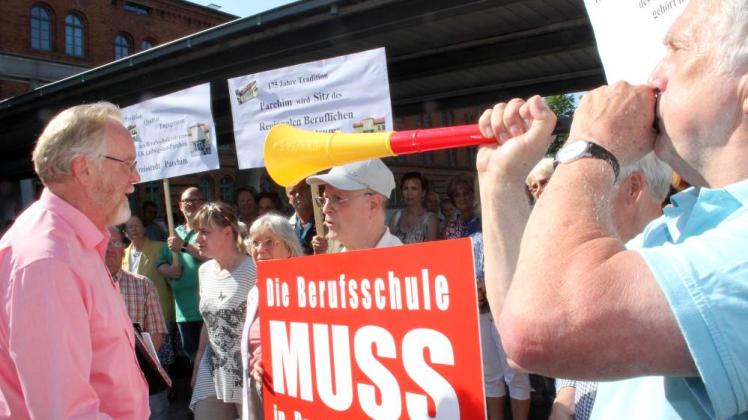 Demonstranten gingen im vergangenen  Sommer  u. a. dafür auf die Straße , dass der Sitz der Berufsschule  in der Kreisstadt bleibt. Landrat Rolf Christiansen (l.)  stellte sich dem Gespräch. Zur Demo hatte der Unternehmerverband aufgerufen. 