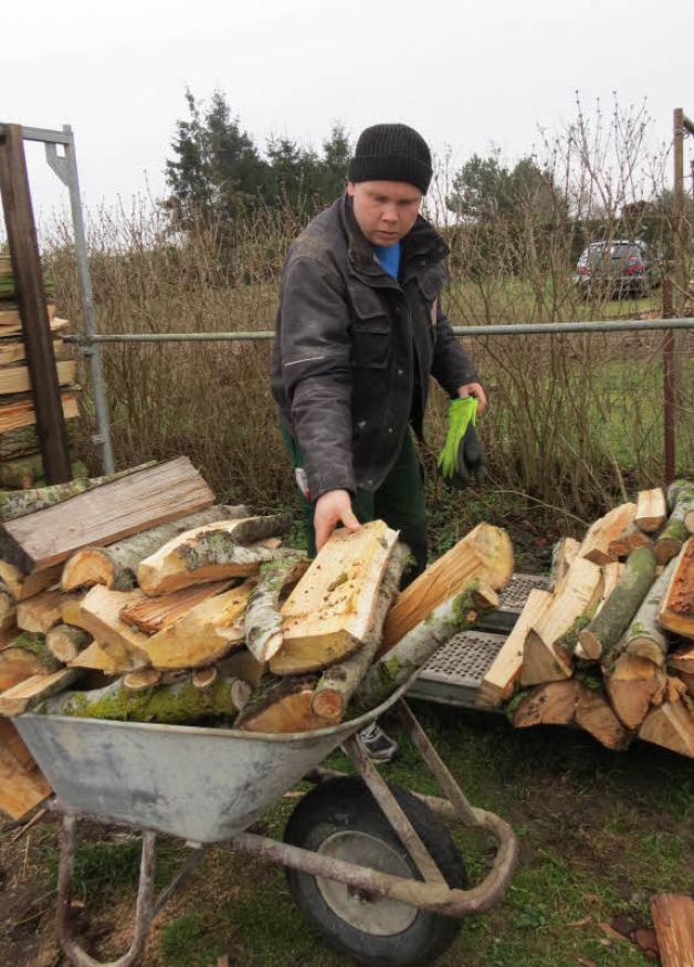 Nachbar Guido Weise schichtet frisch geschlagenes Holz, das zwei Jahre trocknen soll, bevor es dann zum Heizen verwendet werden kann. 