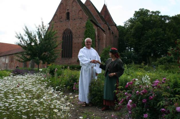 Mönch Ernestus alias Burkhard Schmidt und Eva Doßmann wandeln durch den Hildegard-von-Bingen-Garten am Kloster. 