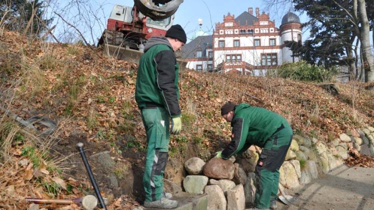 Eine alte Feldsteinmauer schützt den Weg  am Steilhang. Marcel Uter  und Volker Groß   vom  Crivitzer  Garten- und Landschaftsbau richten sie wieder auf.  