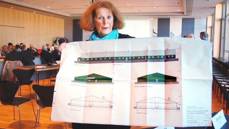 Jutta Förster, eine  Gegnerin des Projekts, präsentiert einen Gebäudeplan.  
