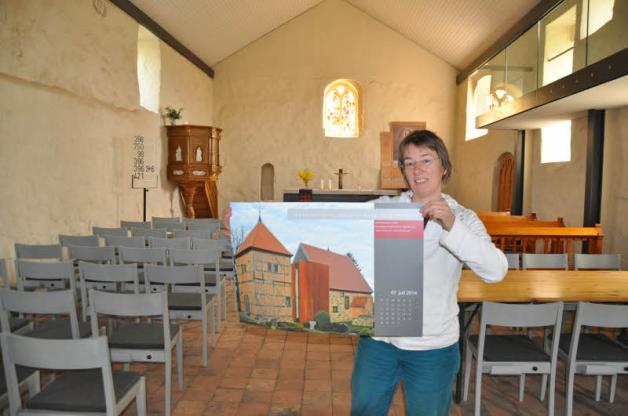 Claudia Huss mit dem Bild der Barkower Kirche aus dem Kalender für 2014, der sie als Gewinner des Landesbaupreises im Jahre 2008 präsentiert 