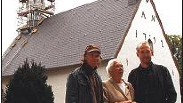 Die Kirche in Toestrup mit Baugerüst, davor: Regisseur Lars Jessen, Renate Delfs und Peter Heinrich Brix (v.l.)