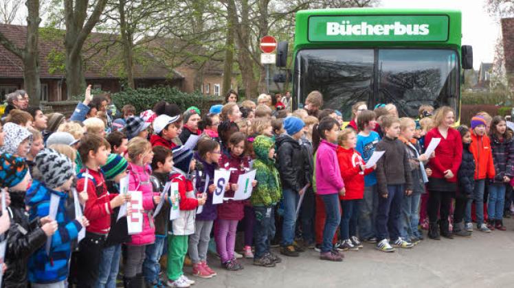 Großer Bahnhof Fruerlund: „Danke, Bücherbus!“ steht auf den Blättern, mit denen die Kinder zum letzten Mal das alte Gefährt vor der Schule begrüßen. 