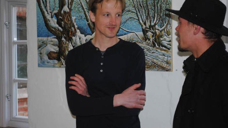 Nils Rackwitz im Gespräch mit seinem Freund Benny Wendt vor dem Gemälde „Am Rand“.  Fotos: Christian Menzel (3) 