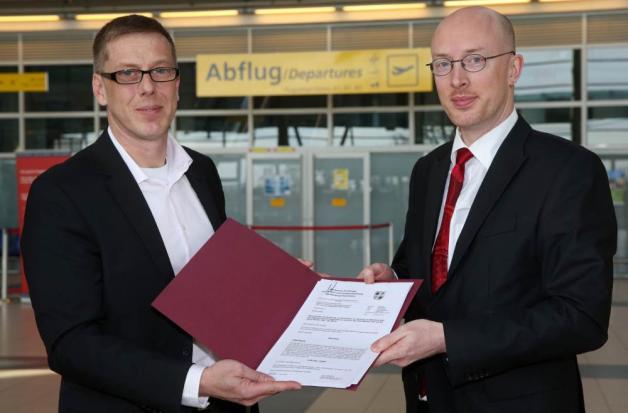 7. Februar 2014: Verkehrsminister Christian Pegel (SPD, r.) bringt  Flughafen-Chef Carsten Herget die erhöhte Landesförderung. Bedingung ist ein Anstieg der Passagierzahlen.