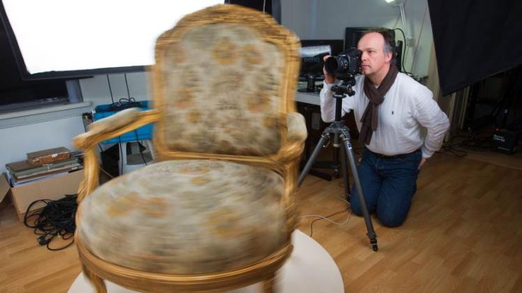 Rundherum wie mit einer Lupe ansehen: Fotograf Gerald Freyer richtet in einem speziellen Fotostudio in Schwerin  die hochauflösende Kamera für Fotoaufnahmen eines barocken Stuhls ein.  