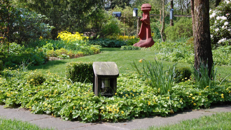Grüne Oase:  Der Blick  wird wie magisch in die Tiefe des  Gartens gezogen. Skulpturen des Hausherren setzen Akzente. 