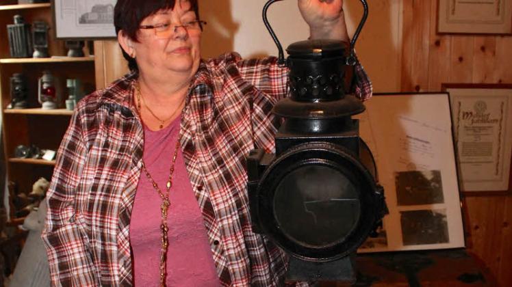Rosemarie Bartelt nimmt eine Eisenbahnerlampe aus dem Regal.   