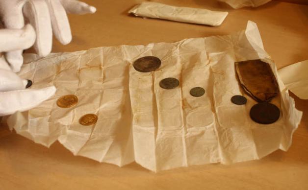 Mit Handschuhen werden die Münzen aus der Zeit  zwischen 1647 und 1841 ausgepackt.   
