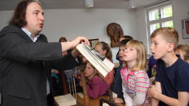 Tilmann Wesolowski zeigt, woran man sieht, wie das Buch gebunden wurde.  