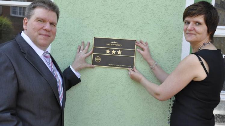Jürgen Griese und Cornelia Muuß testen, wie  die drei Sterne an der Hausfassade aussehen. 