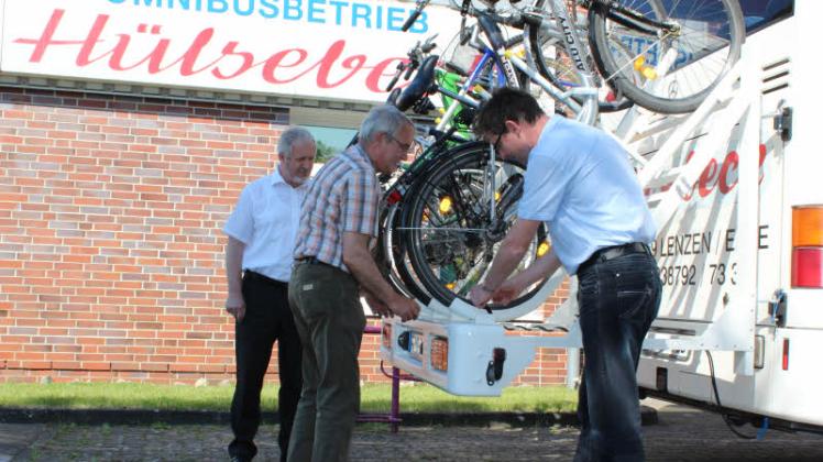 VGP-Geschäftsführer Manfred Pause (l.) beobachtet, wie Landkreis-Mitarbeiter Andreas Much und Busunternehmer Uwe Hülsebeck den Hecklastträger mit Fahrrädern bestücken. 