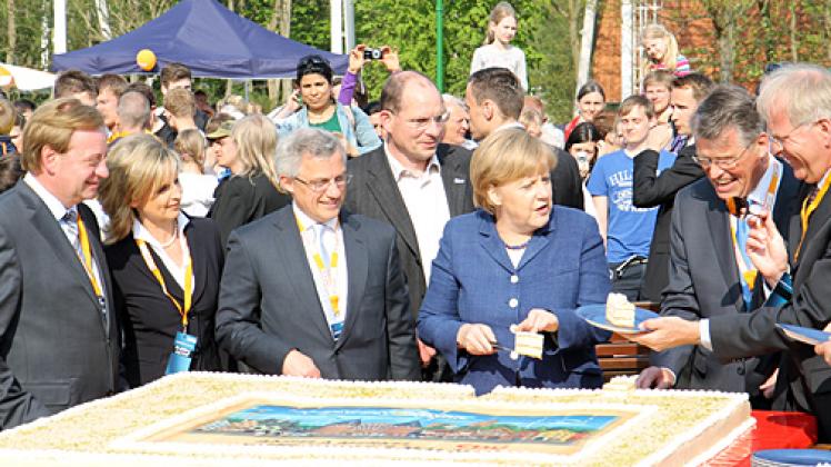 Angeschnittene Ostholstein-Torte: Angela Merkel, Landes-CDU-Vorsitzender Reimer Böge (2.v.r.) und Ostholsteins Landrat Reinhard Sager (r.) verteilen die Stücke. Foto: Käfer