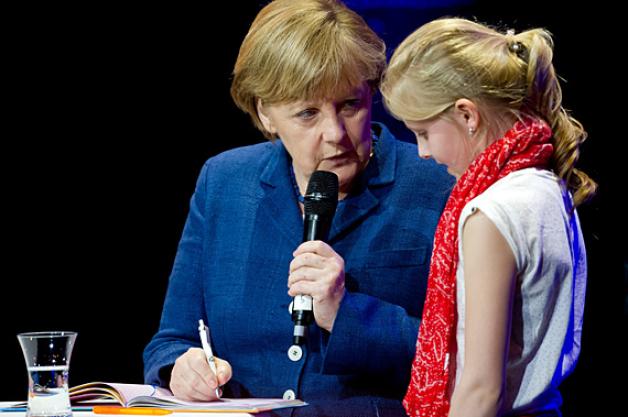 Die Bundeskanzlerin schreibt der neun Jahre alten Luca eine Widmung ins Poesiealbum. Foto: dpa Die Bundeskanzlerin schreibt der neun Jahre alten Luca eine Widmung ins Poesiealbum. Foto: dpa