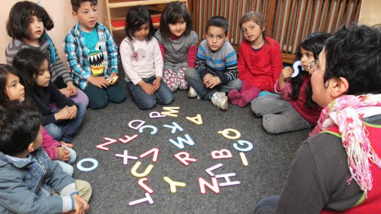 Vorbild auch für andere Kitas? Im ADS-Kindergarten Schulgasse – in einem Flensburger Stadtteil mit einem hohen Ausländeranteil – lernen die Kinder spielerisch die deutsche Sprache. Die türkischstämmige Erzieherin nutzt Buchstaben, mit denen die Kinder Worte bilden. 