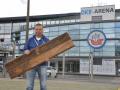 Juri Schlünz mit einer  Sitz-Holzplanke aus dem  alten Ostseestadion. An dieser Stelle rechts hinter ihm wird bald statt des Feuerwehrtores  das rekonstruierte Marathontor stehen.  