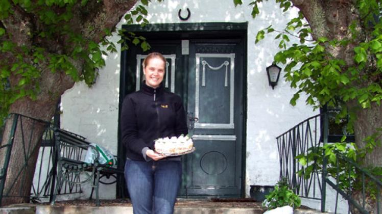 Sonja Karberg auf den Stufen zur Landarztpraxis. Ab sofort serviert sie hier Kaffee und Kuchen. Foto: Hamisch