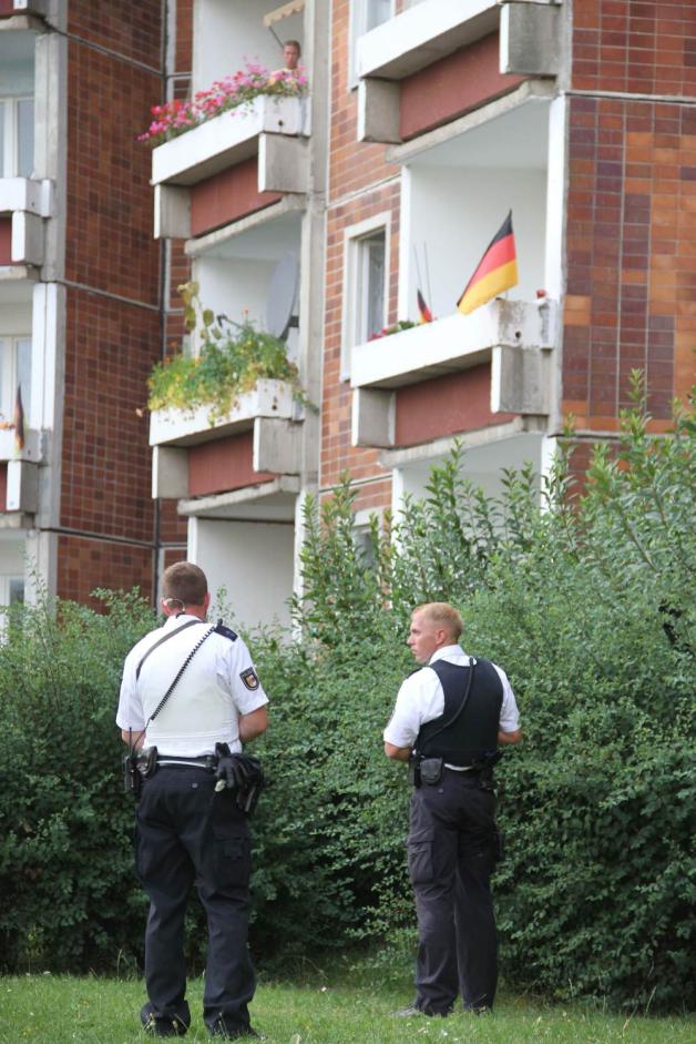 Mit Maschinenpistolen umstellt die Polizei das Haus, behält den Balkon im ersten Stock im Visier. Mit Maschinenpistolen umstellt die Polizei das Haus, behält den Balkon im ersten Stock im Visier.