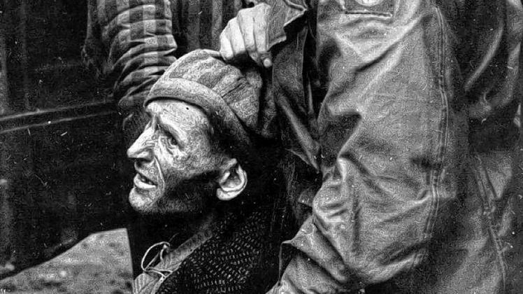 Der amerikanische Feldgeistliche Philip Matthew Hannan stützt einen befreiten Häftling des KZ Wöbbelin, der vor Erschöpfung und Glück weint. Das Foto entstand am 5. Mai 1945 in Wöbbelin.
