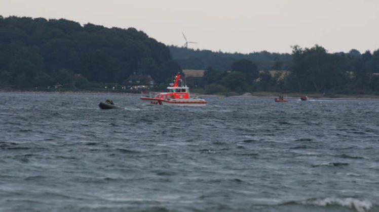 Vier Boote suchen das Küstenstück zwischen dem im Hintergund erleuchteten Restaurant Strandgut und dem WTD nach dem Vermissten ab.
