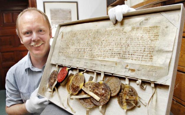 Stadtarchivar Karsten Schröder mit einer Urkunde vom 9. September 1361, die den Zusammenschluss der Hansestädte Rostock, Lübeck, Hamburg und anderer, Schwedens und Norwegens gegen den mächtigen Dänenkönig Waldemar IV. besiegelte. Fotos: Georg Scharnweber Stadtarchivar Karsten Schröder mit einer Urkunde vom 9. September 1361, die den Zusammenschluss der Hansestädte Rostock, Lübeck, Hamburg und anderer, Schwedens und Norwegens gegen den mächtigen Dänenkönig Waldemar IV. besiegelte. Fotos: Georg Scharnweber