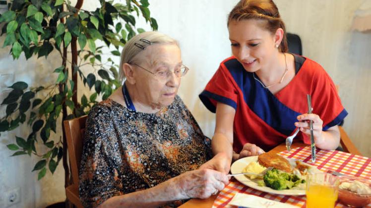 Katrin  Schwarz   (r.) hilft   im  Schweriner Vitanas  Senioren  Centrum  am  Schlossgarten  einer  Bewohnerin    beim  Mittagessen.  