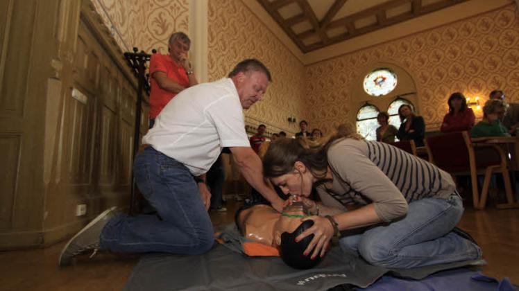 Rainer Neumann (l.) und Lena Bender üben unter den kritischen Blicken von Notarzt Dr. Thomas Libuda (im roten T-Shirt) die richtigen Handgriffe zur Herzdruckmassage und Beatmung.  