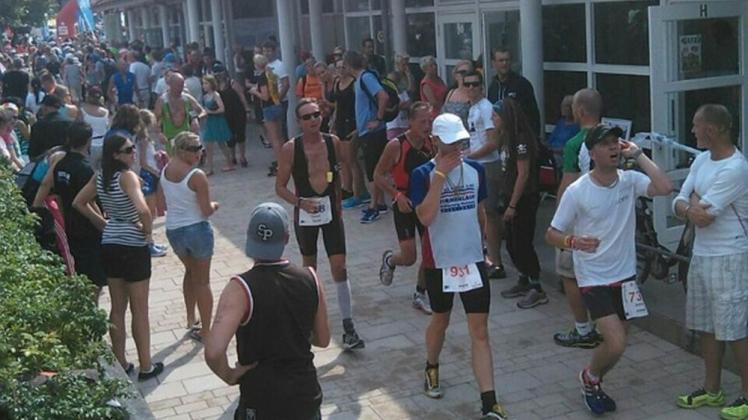 Triathlon hautnah: Thomas Teige auf der Laufstrecke, beobachtet von Touristen